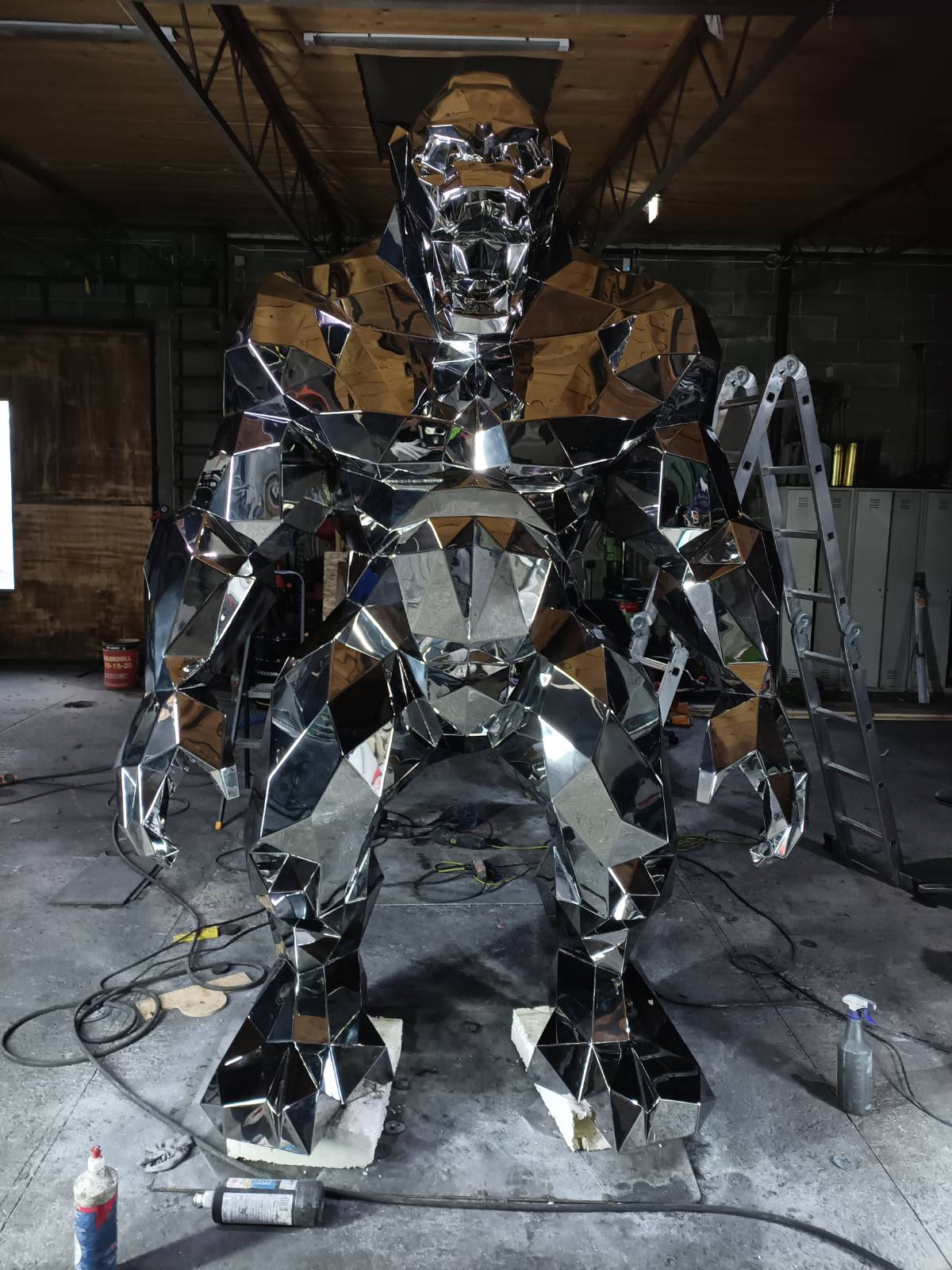Large metallic insect sculpture of Gorillas in a workshop setting