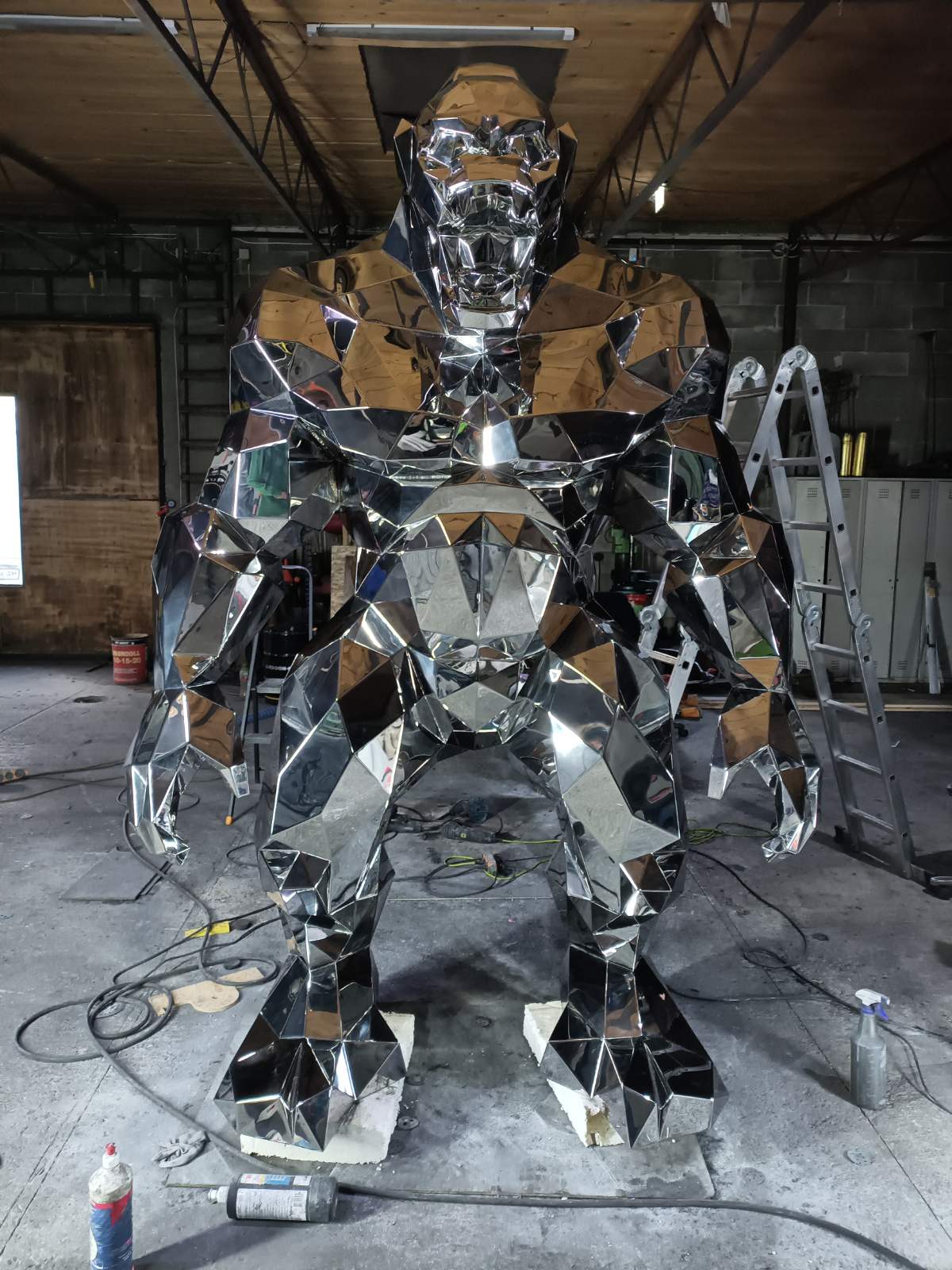 Large metallic sculpture in a workshop setting