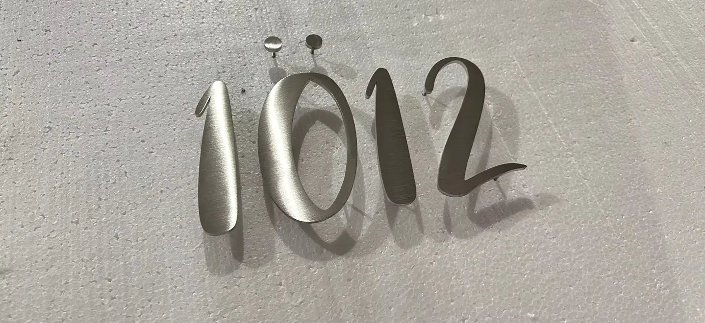 Metallic numbers '1012' on a textured gray background
